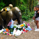 Young visitors view a bronze statue of a gorilla and its baby surrounded by flowers outside the Cincinnati Zoo’s Gorilla World exhibit June 2, 2016, days after a 3-year-old boy fell into the habitat and officials were forced to kill Harambe, a 17-year-old silverback gorilla.
John Sommers II/Getty Images